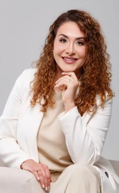 Retrato da Dra. Ana Paula Naspolini sorrindo, com a mão apoiada no queixo